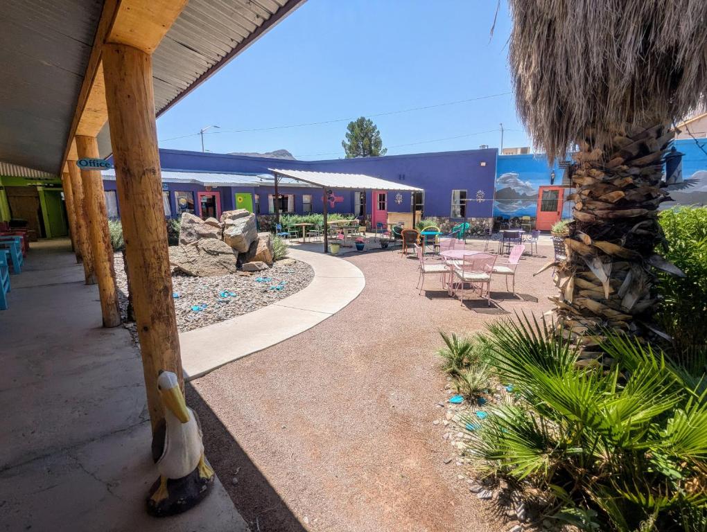 a patio with a table and chairs and a building at Pelican Spa in Truth or Consequences