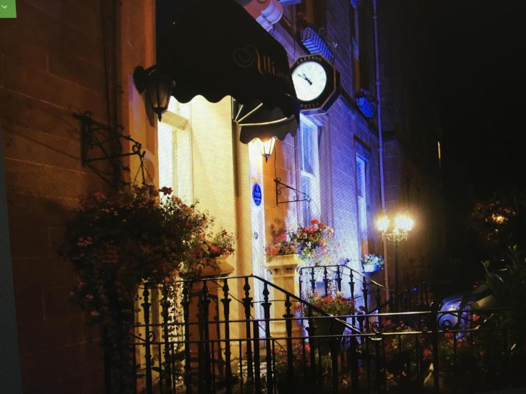 un orologio sul lato di un edificio di notte di Allison House 17 a Edimburgo