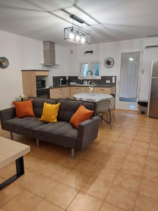un salon avec un canapé et une cuisine dans l'établissement Au pied des alpilles, à Eyguières