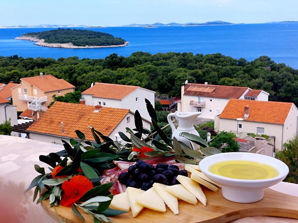 a plate of food with cheese and fruit on a table at Apartments Tonći and Iris in Primošten