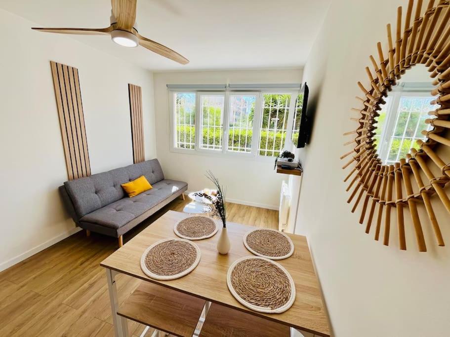 un salon avec une table et un canapé dans l'établissement L'Escale T2 neuf à 50m de la plage, à Marseille