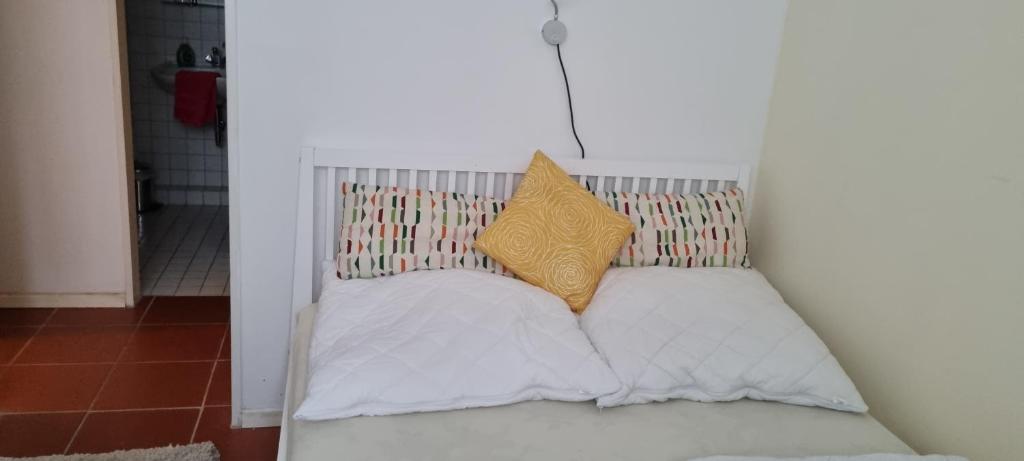 a white bed with two pillows on top of it at Rosa Canina W2 in Kellenhusen
