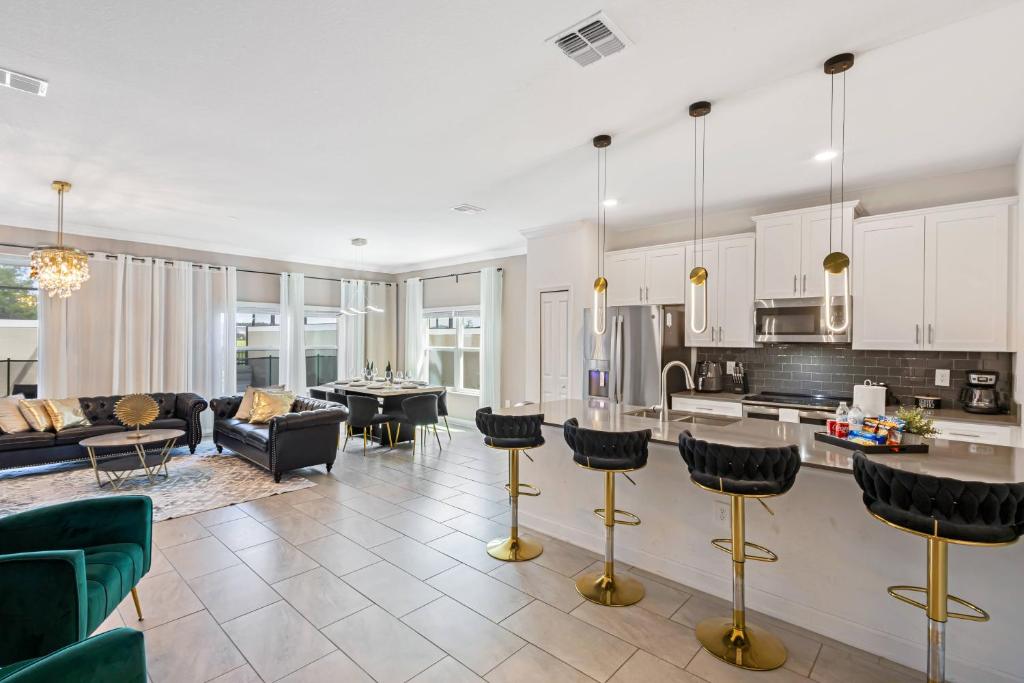 een keuken en woonkamer met een bank en een tafel bij 4327 Create Memories in a Magical 5BD Home in Kissimmee