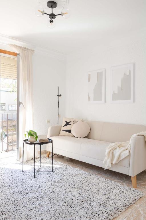 a white living room with a white couch and a table at Apartamento Esperanza by Clabao in Logroño