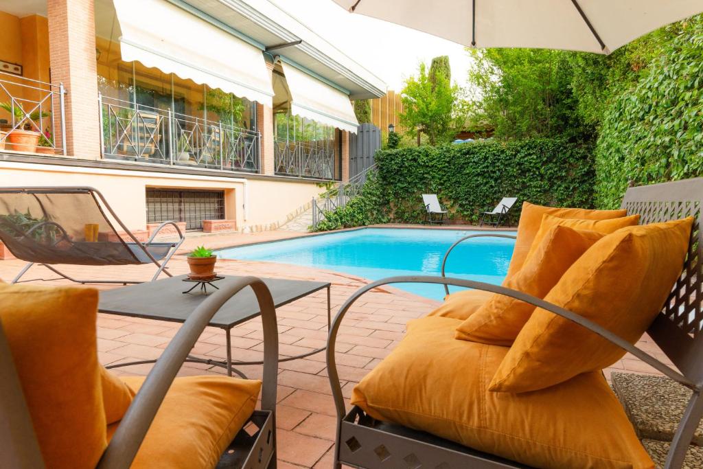 a patio with a table and chairs and a pool at Villa Aureliana with pool near San Peter in Rome