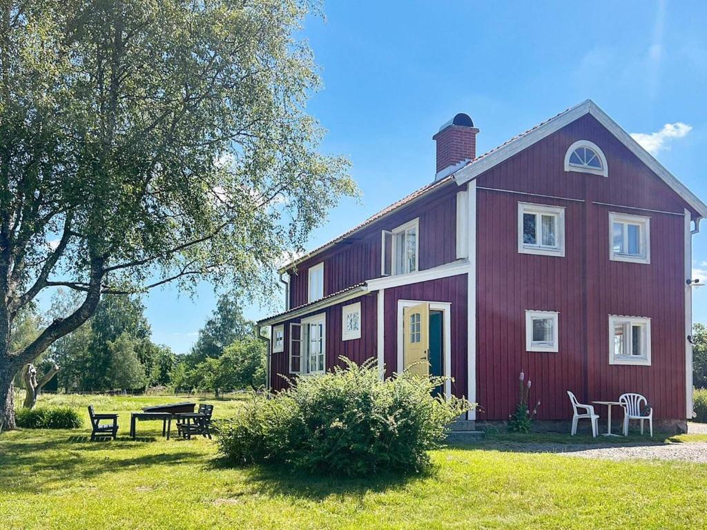 a red house with a picnic table in front of it at 5 star holiday home in Urshult in Urshult