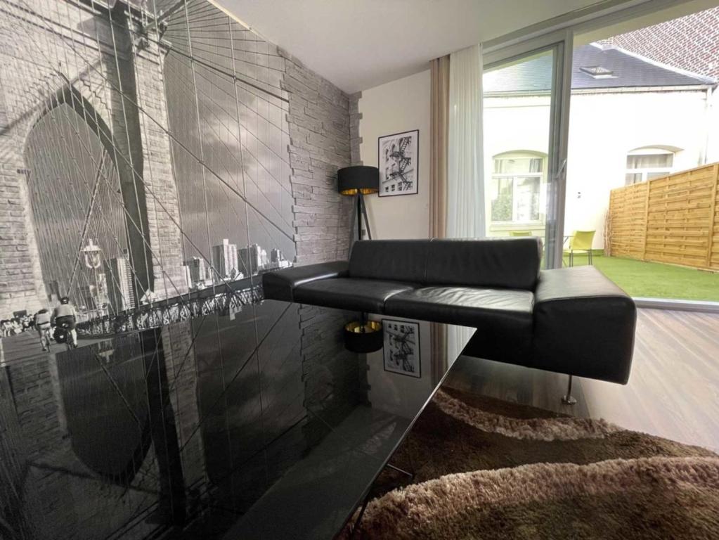 a black bench in a room with a wall at Logis Hôtel & Restaurant - Le Mouton Blanc in Cambrai