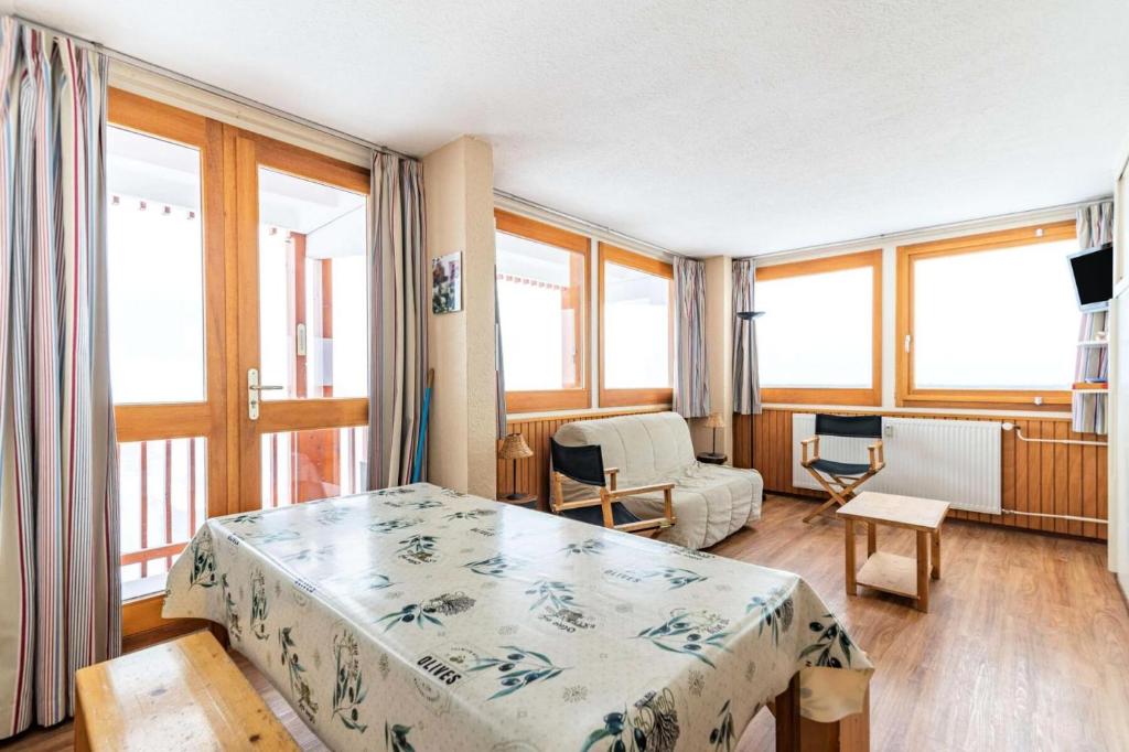 Cet appartement comprend une chambre avec un lit et un salon avec des fenêtres. dans l'établissement Résidence L'everest - 2 pièces 5 pers - L'EVEREST - PLAGNE CENTRE MAE-9034, à Aime La Plagne
