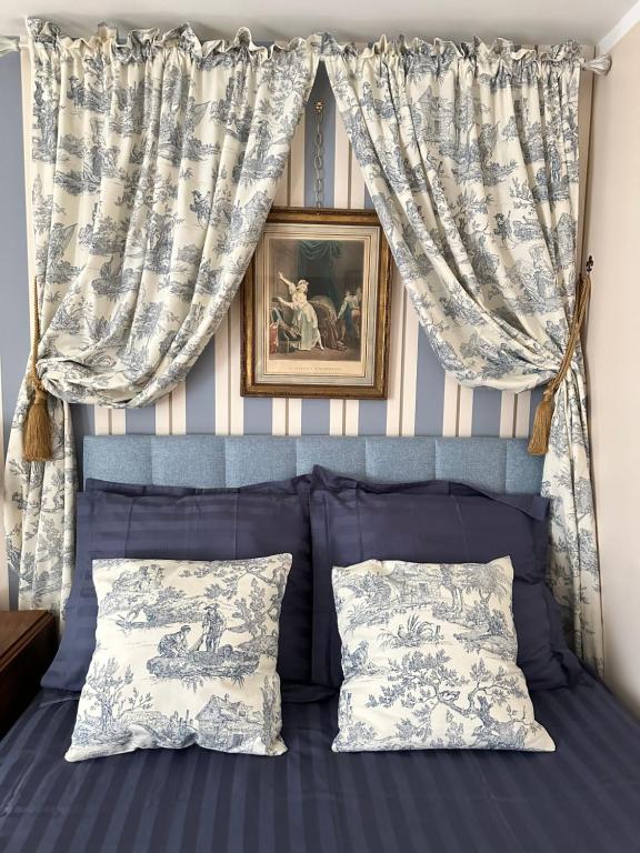une chambre avec un lit bleu avec des rideaux et des oreillers dans l'établissement Évasion Parisienne !, à Paris