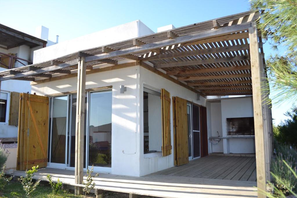 una pérgola sobre un porche de una casa en Complejo Alcobas del Diablo, en Punta del Diablo