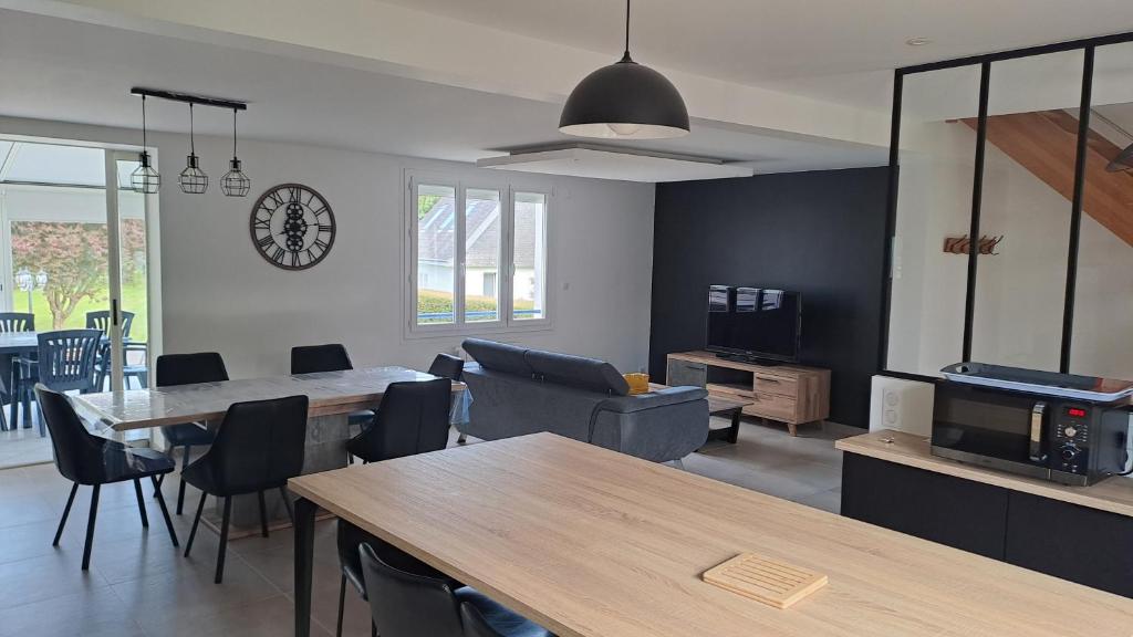 - un salon avec une table, des chaises et une horloge dans l'établissement Grande Maison au calme à 5mn de la plage, à Moëlan-sur-Mer