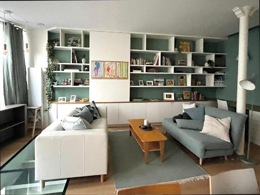un salon avec un canapé et une table dans l'établissement Charming family loft near the Parc de Belleville, à Paris