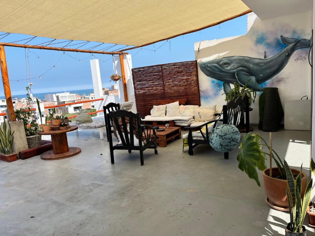 eine Terrasse mit Tisch und Stühlen und einem Delphin an der Wand in der Unterkunft Bravo Hostels: Surf House in Punta Hermosa