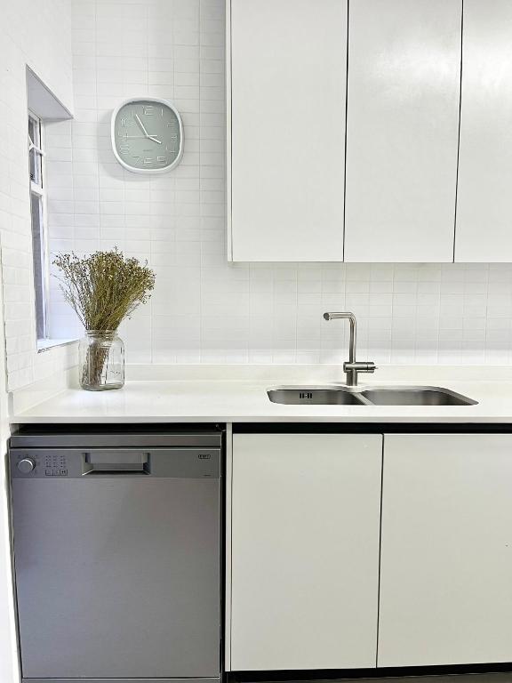 a white kitchen with a sink and a dishwasher at Thornhill Tranquility in Pretoria