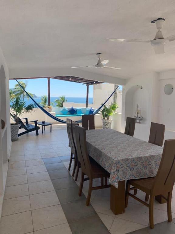 a dining room with a table and chairs and the ocean at Casa Las iguanas in Acapulco