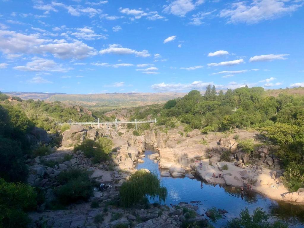 Blick auf einen Fluss mit einer Brücke im Hintergrund in der Unterkunft Casa Safari en La Paisanita, Alta Gracia in Alta Gracia