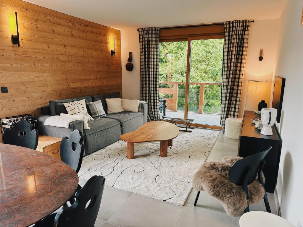un salon avec un canapé et une table dans l'établissement L'Olympe de Combloux - Terrasse & balcon sur la forêt, à Combloux