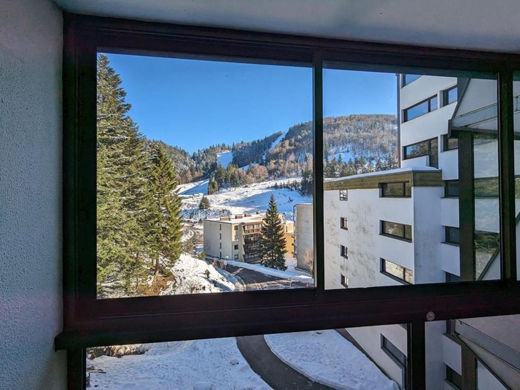 une fenêtre avec vue sur une montagne enneigée dans l'établissement Refuge AuRoiSud, à La Bresse