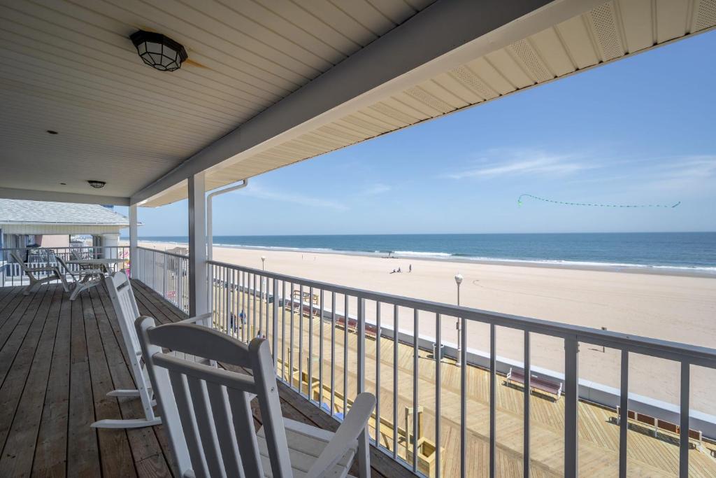 a porch with two white benches on the beach at OCHG Lankford Oceanfront Penthouse in Ocean City