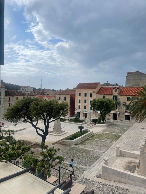 a person walking through a courtyard with buildings at Old town Pjaca Makarska in Makarska