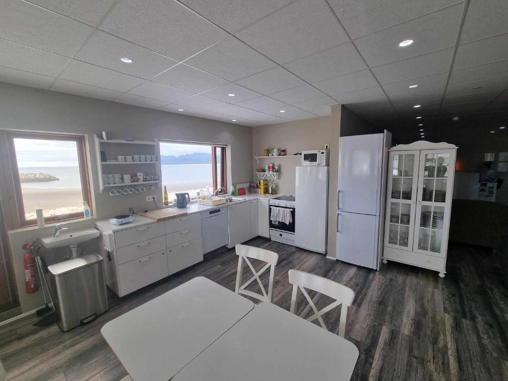 een keuken met witte apparatuur en een tafel en stoelen bij Við Hafið Guesthouse in Ólafsvík