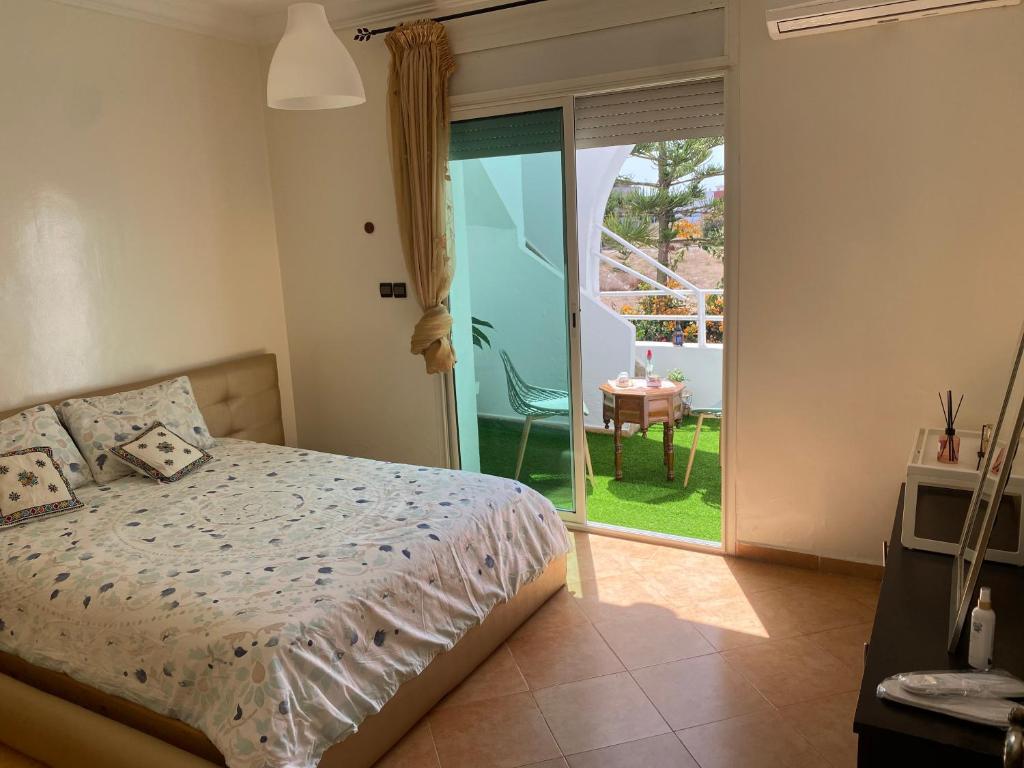 a bedroom with a bed and a door to a patio at calm and secure residence with pool in Sidi Bouzid