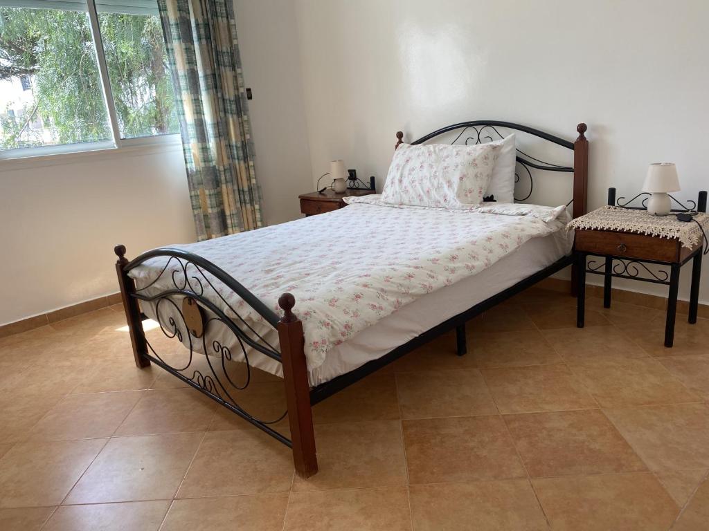 a bedroom with a bed and a chair and a window at calm and secure residence with pool in Sidi Bouzid