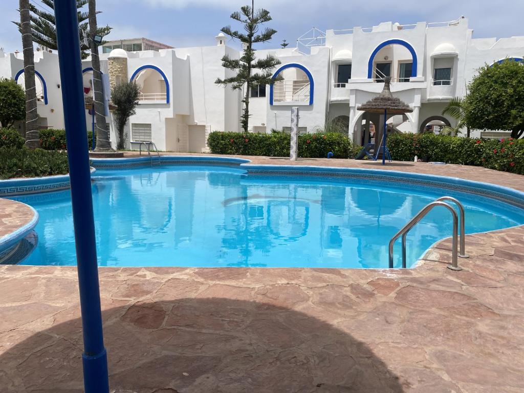 a large swimming pool in front of a building at calm and secure residence with pool in Sidi Bouzid