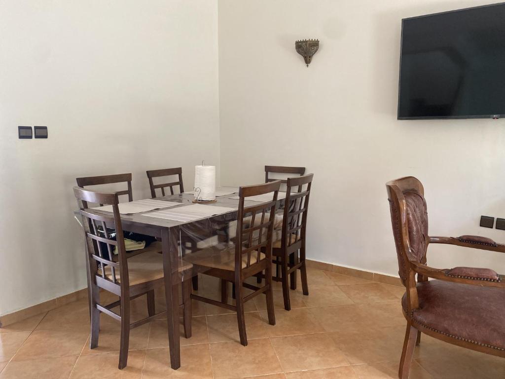 a dining room with a wooden table and chairs at calm and secure residence with pool in Sidi Bouzid
