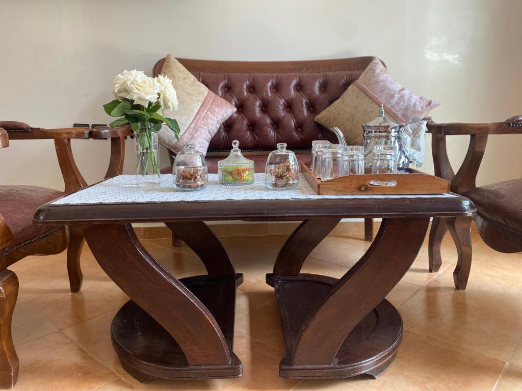 a wooden coffee table with a vase of flowers on it at calm and secure residence with pool in Sidi Bouzid