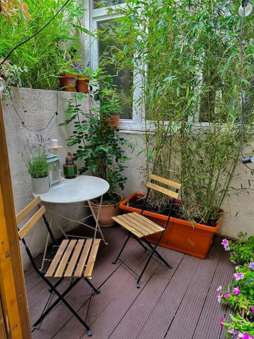 une terrasse avec une table, deux chaises et des plantes dans l'établissement Charming studio in a courtyard in Paris, à Paris