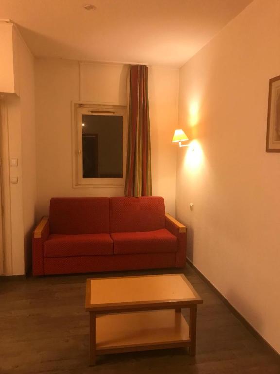 un salon avec un canapé rouge et une table dans l'établissement Appartement Chamonix, à Chamonix-Mont-Blanc