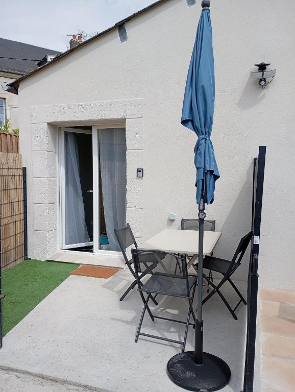 une table et des chaises avec un parasol sur une terrasse dans l'établissement Com'cz soi, à Bourges