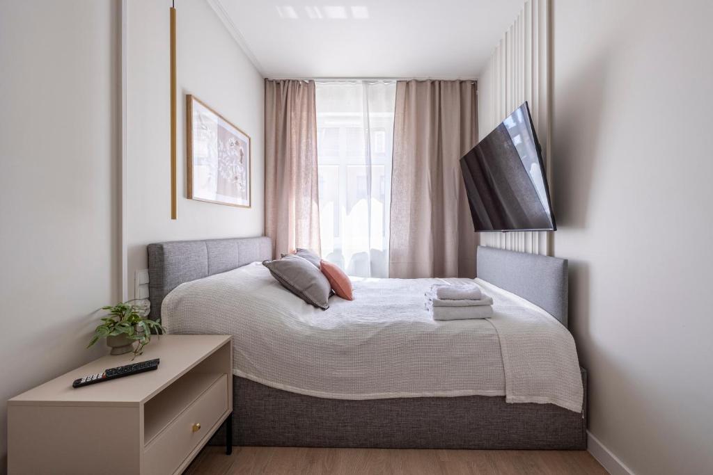 a small bedroom with a bed and a window at Comfy Aparts Plac Solny II in Głogów