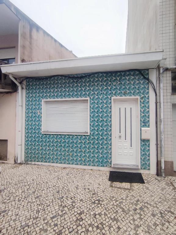 a building with a white door on the side of it at Seventy House By Furabeach in Furadouro