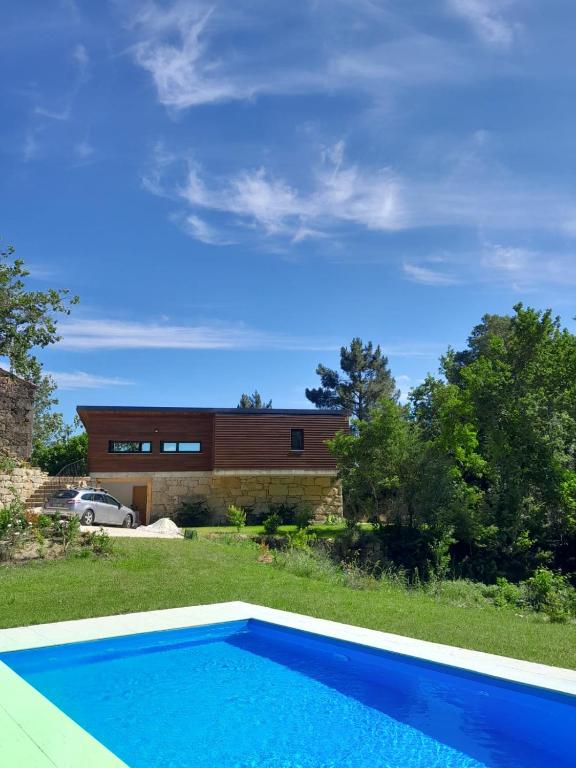 a house with a blue swimming pool in front of a house at Quinta do Chão do Vale in Sever do Vouga