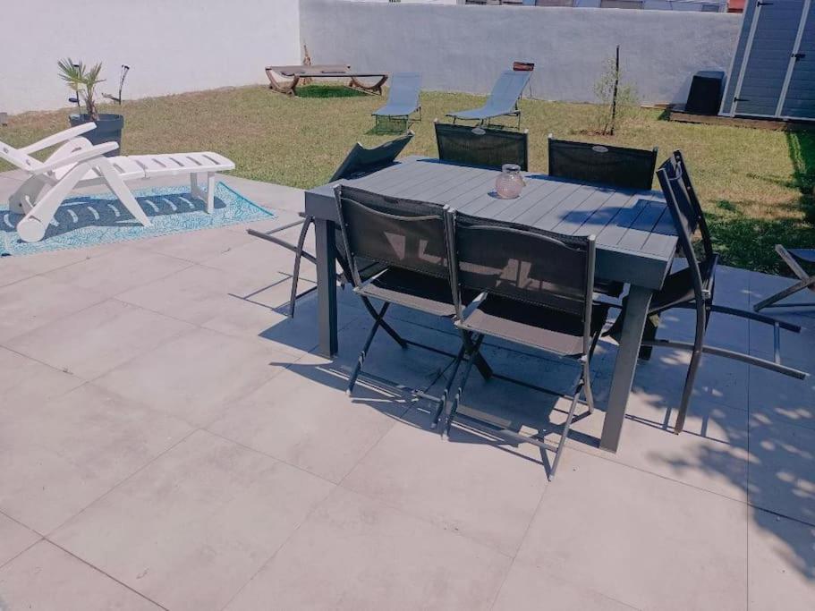 a table with chairs and a bird sitting on top of it at Maison plain pied 2 chambres in Fouras