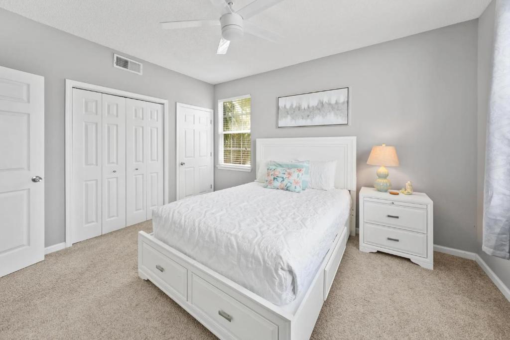 ein weißes Schlafzimmer mit einem weißen Bett und einem Fenster in der Unterkunft Sunny escape in Miramar Beach in Destin
