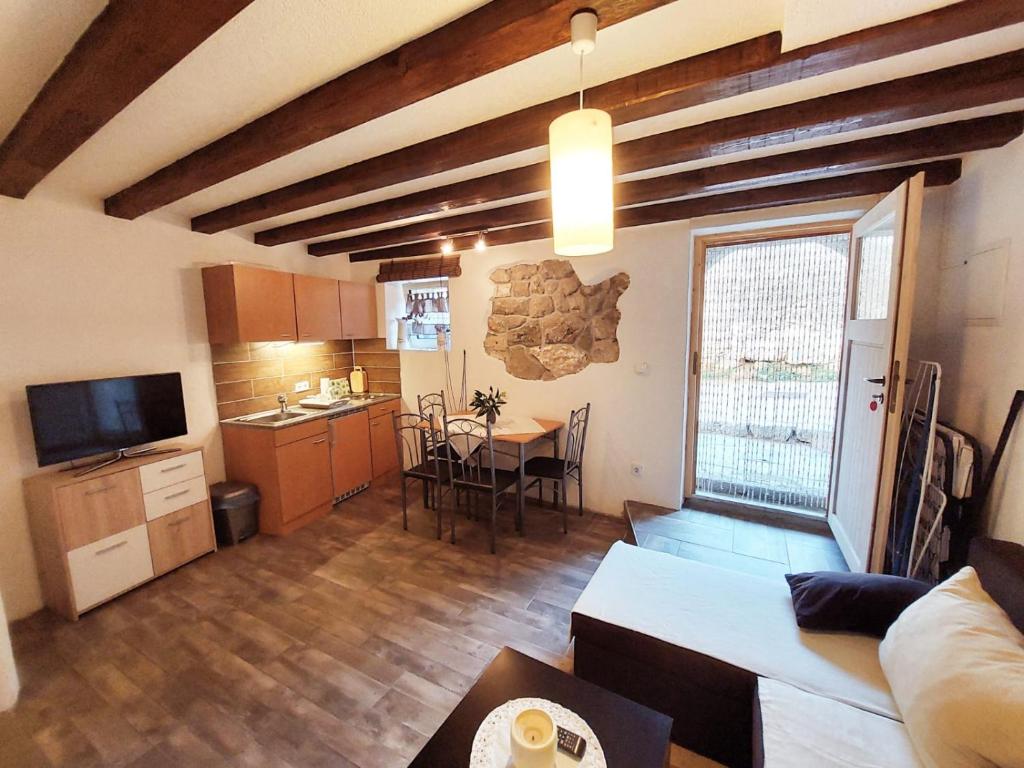 a large living room with a table and a kitchen at Anana Apartment in Cres