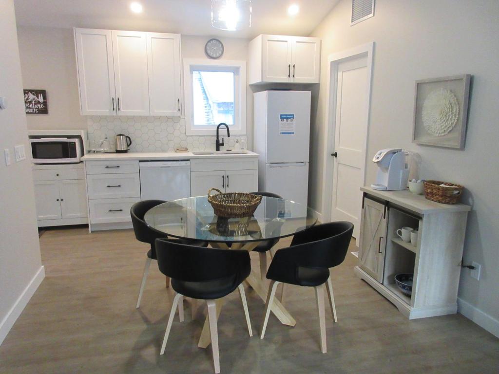 a kitchen with a glass table and black chairs at Mountain View Bed & Breakfast in Banff