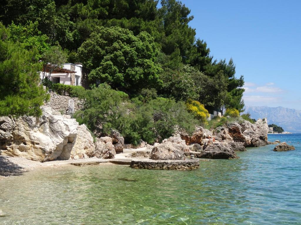 a rocky shore with a house in the water at Holiday Home Waterfront Omis in Omiš