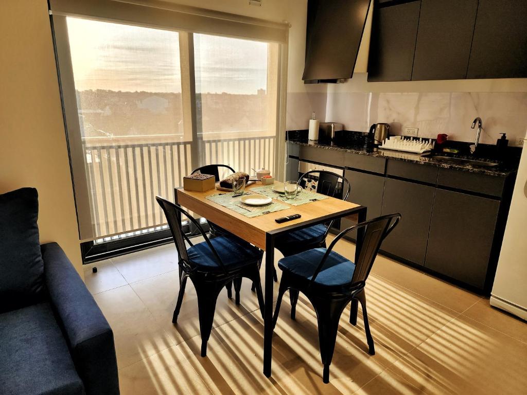 a kitchen with a wooden table and chairs in a room at UmanKuyen Aire y Agua in Mar del Plata