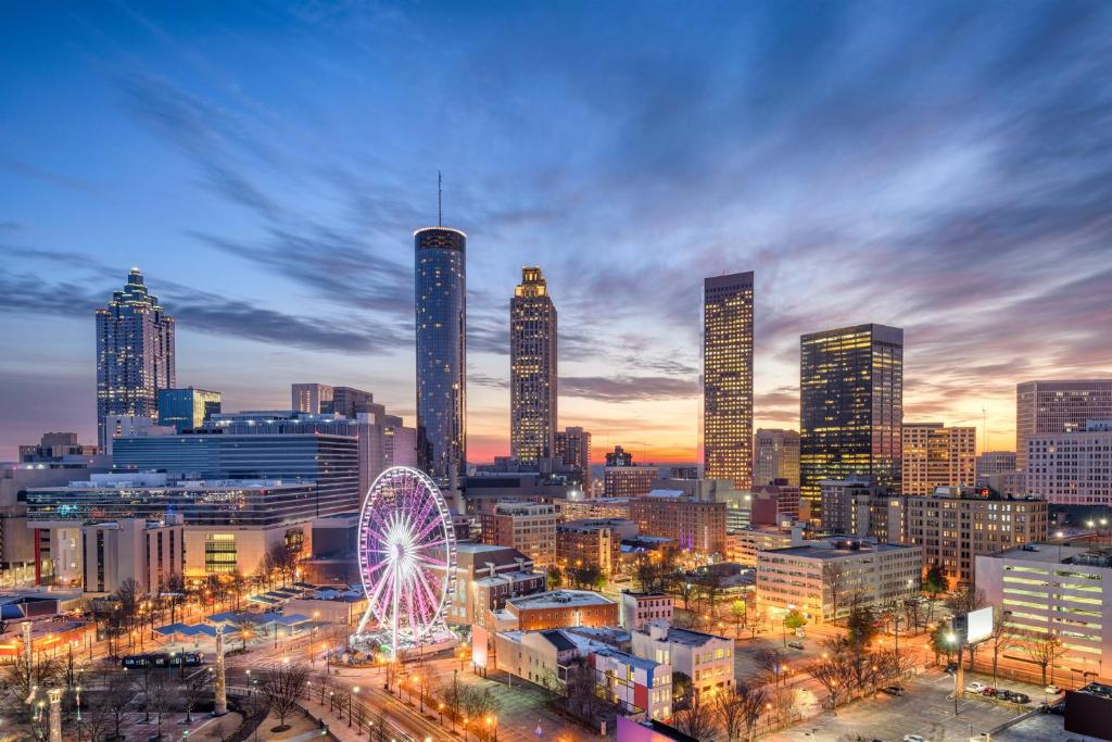 a city skyline at night with a ferris wheel at Hotel Indigo Atlanta Downtown by IHG in Atlanta