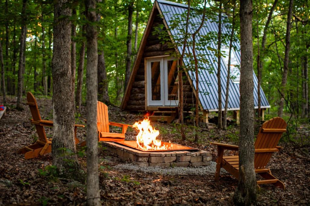 a fire pit in front of a cabin in the woods at tiny A frame in the woods in Lincoln