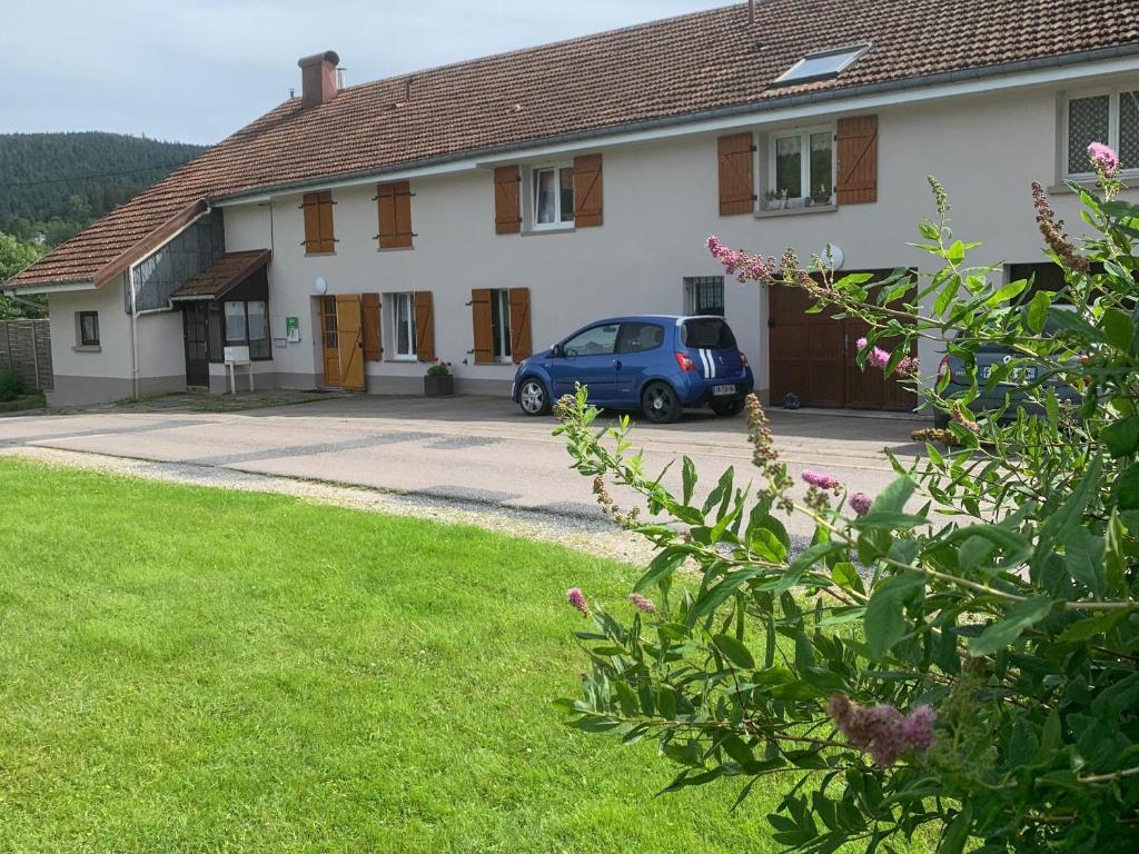 a blue car parked in front of a house at Gîte paisible avec terrasse et WIFI, proche de Gérardmer - 2 chambres, animaux acceptés - FR-1-589-216 in Liézey