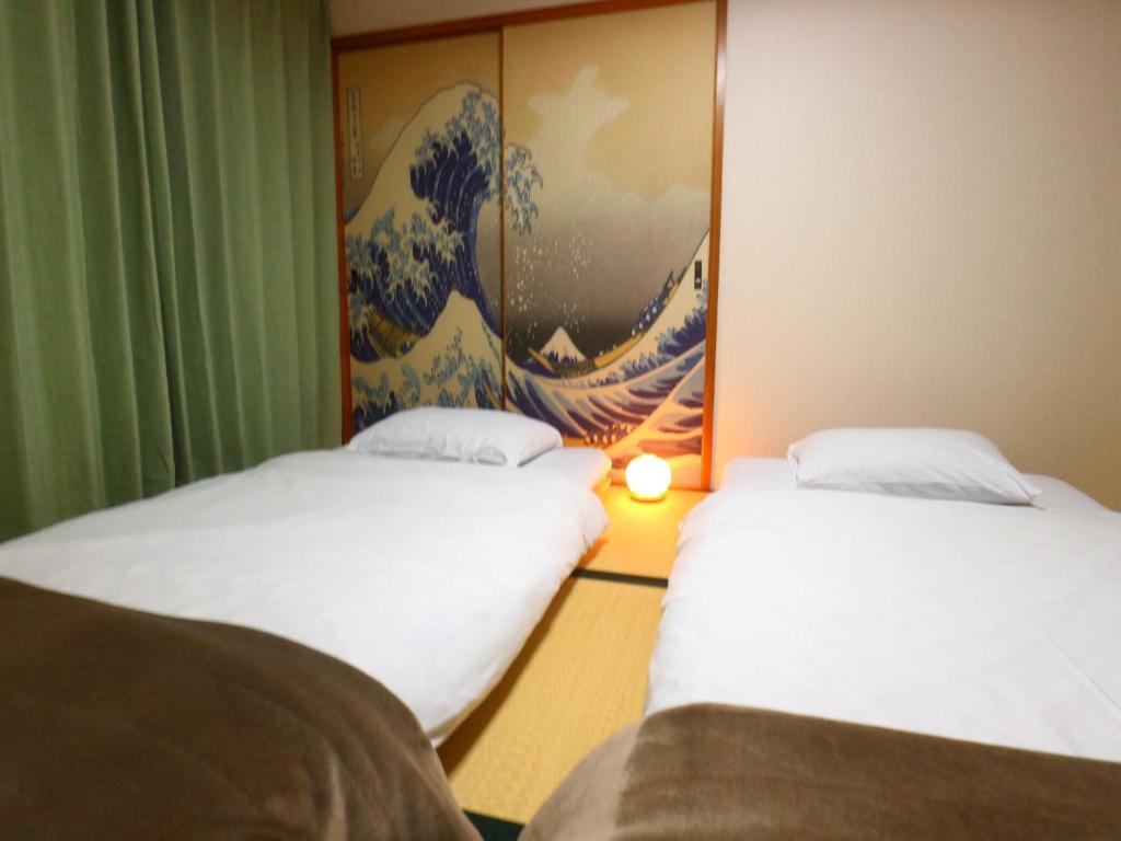 富士吉田市富士山結アパートメント的墙上画画的房间里设有两张床