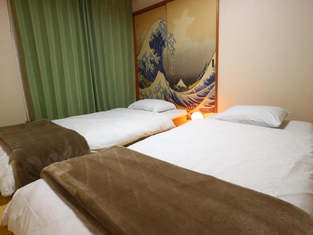 富士吉田市富士山結アパートメント的墙上画画的房间的三张床