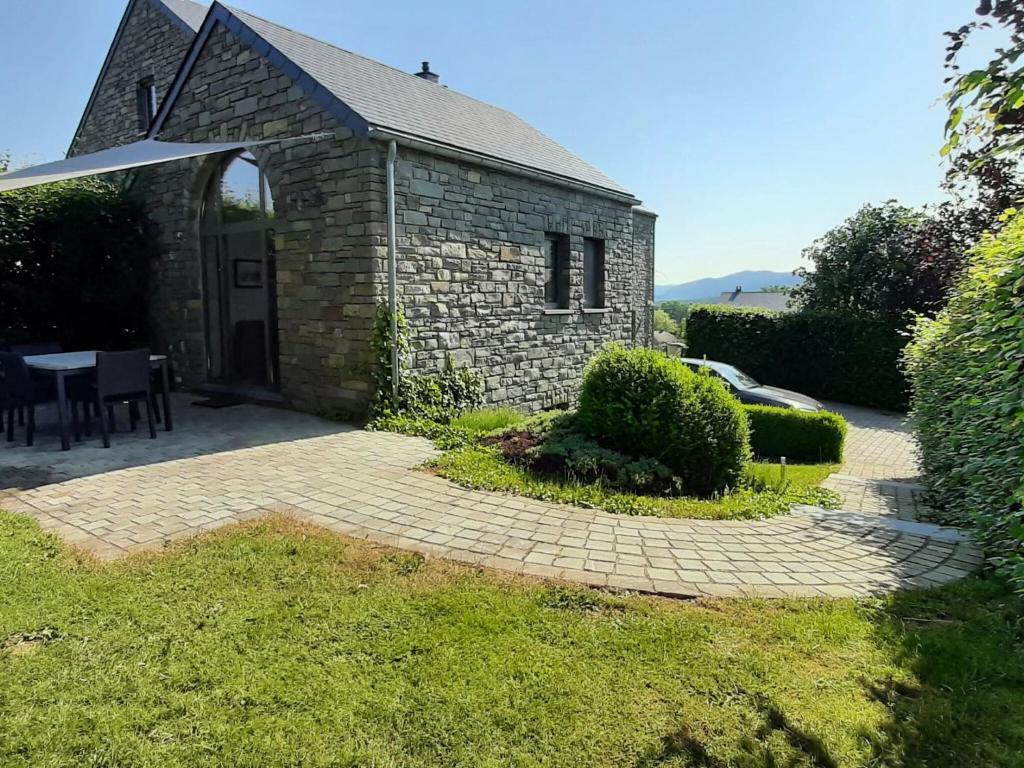 ストゥモンにあるScenic Cottage in Rahierのレンガ造りの建物で、テーブルとパティオが付いています。