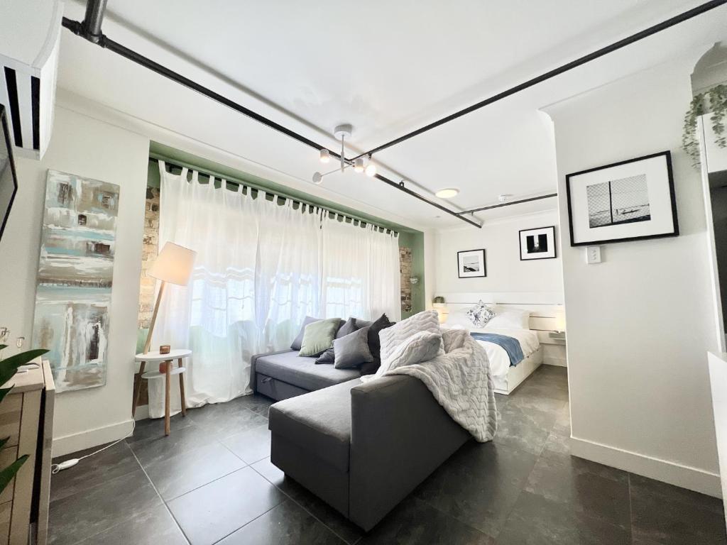 a living room with a couch and a bed at Stylish Studio in the Heart of the City in Brisbane
