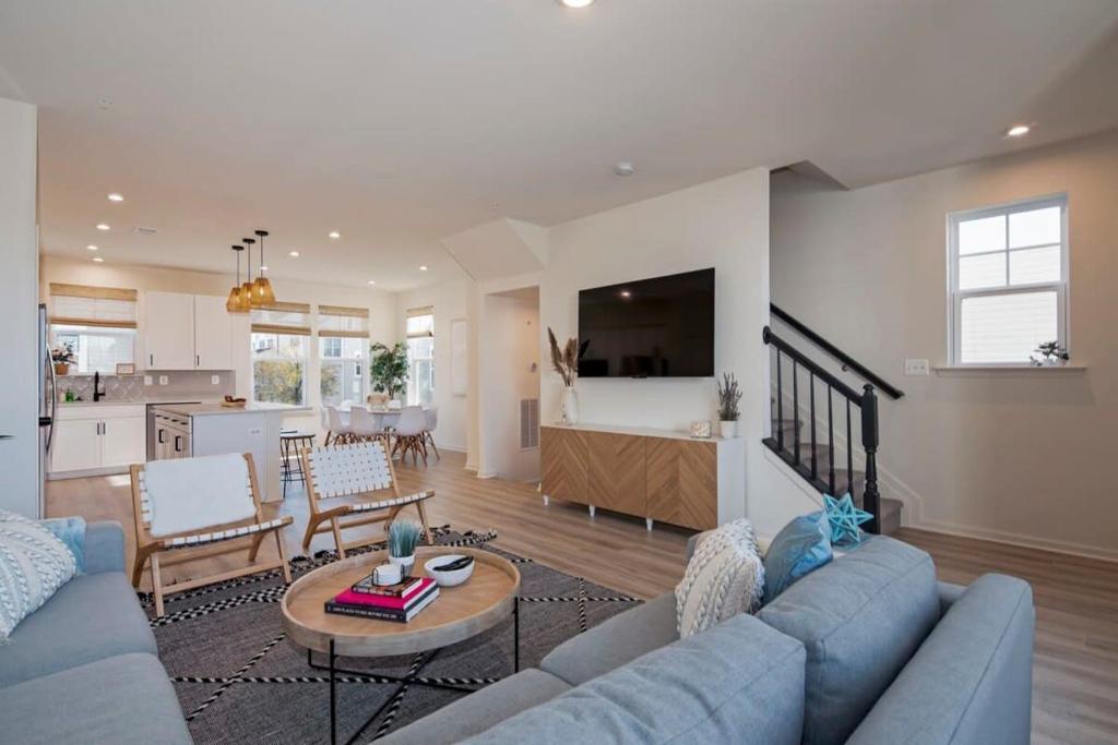 a living room with a blue couch and a table at New Intown Waterfront Townhome wPool & Location in Cambridge